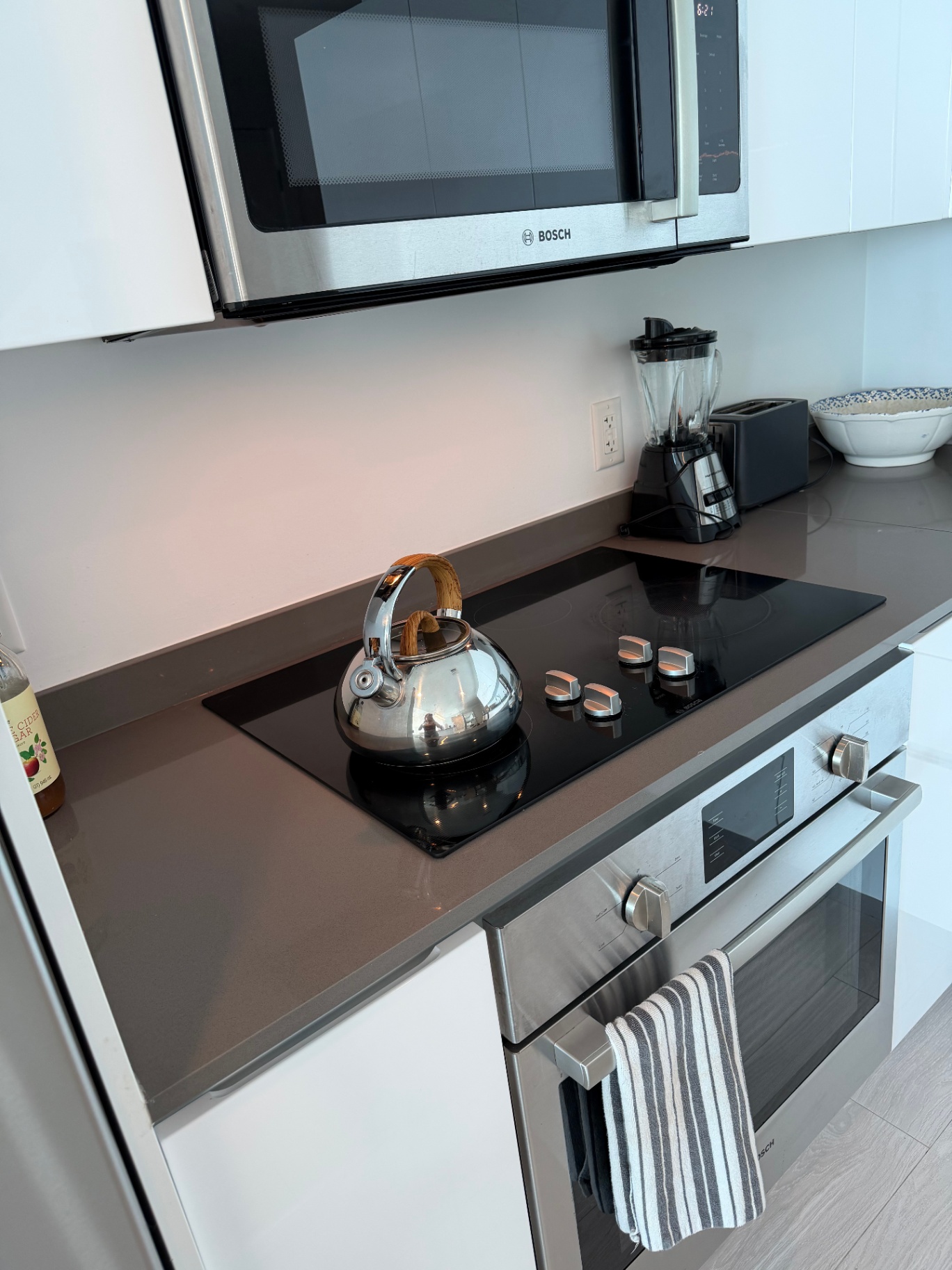 Polished cooktop, stainless appliances and clean quartz counters after a professional cleaning