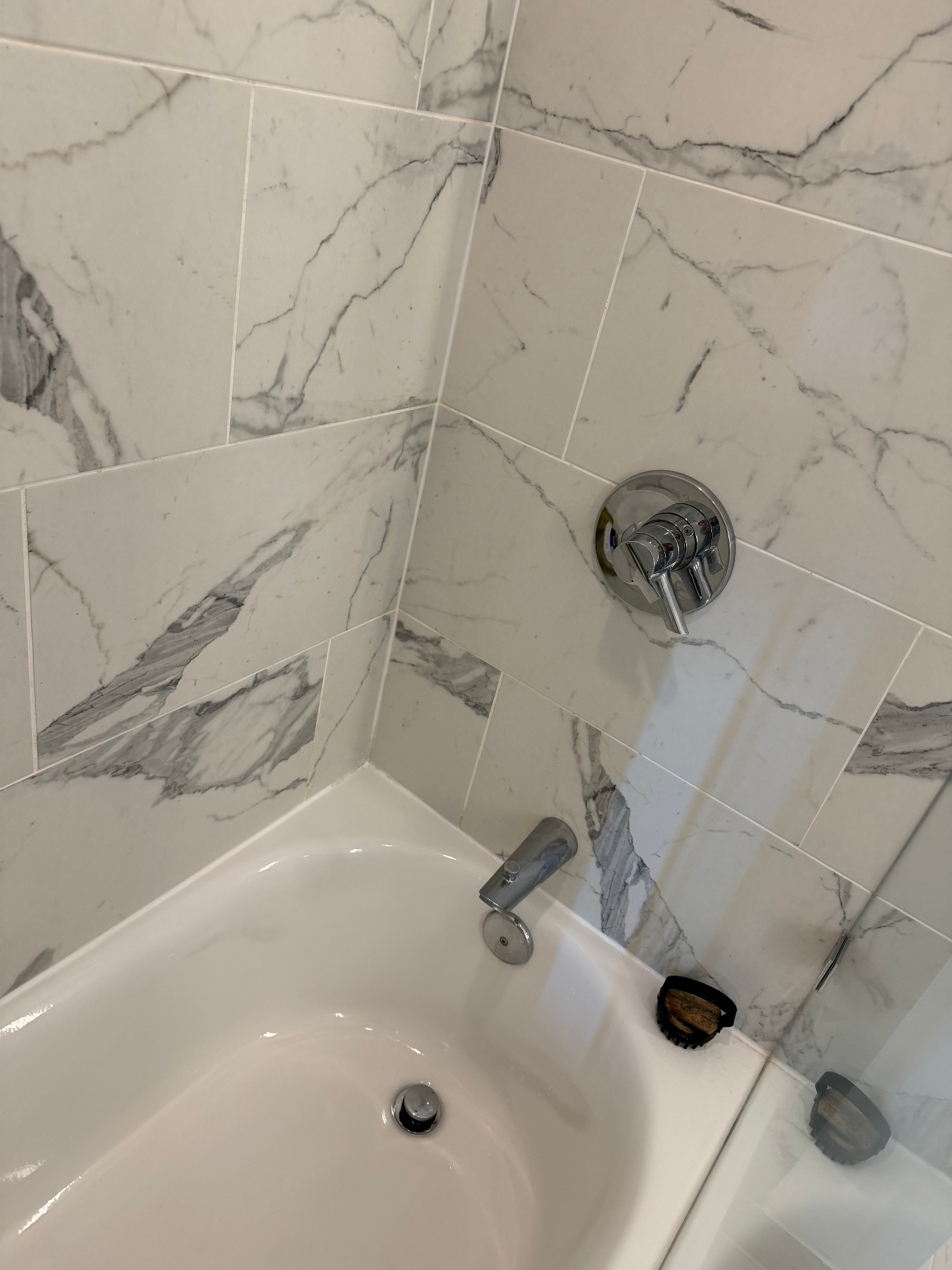 Gleaming white bathtub and polished marble tile after cleaning