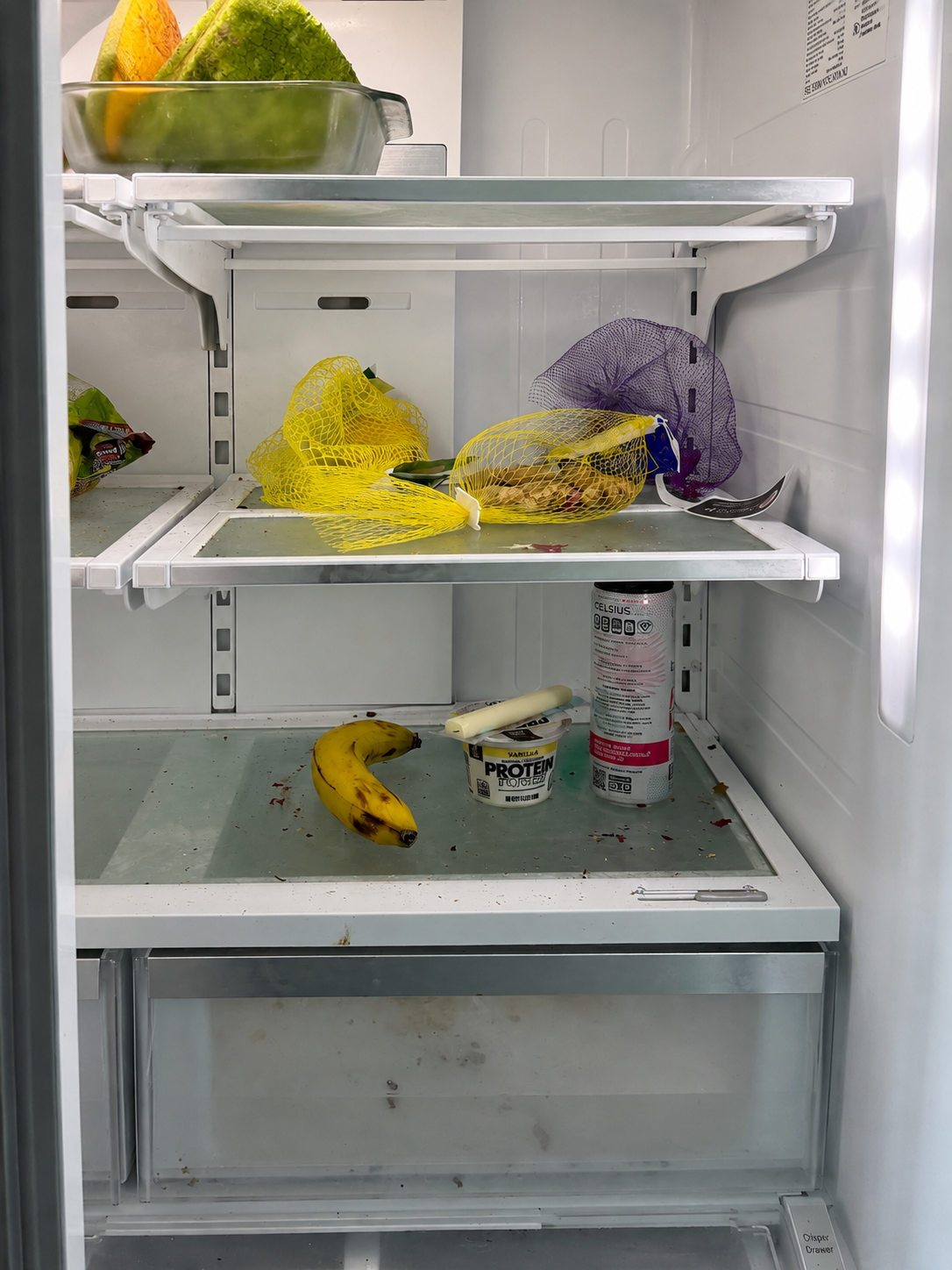 Refrigerator shelves with crumbs, spills and leftover food before cleaning